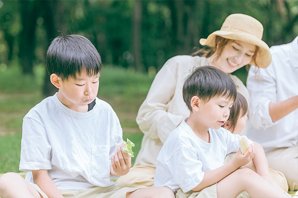 ピクニックをしている子ども達と大人